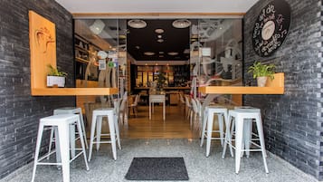 Un interior moderno con una zona de bar, asientos y una paleta de colores blanco y negro.