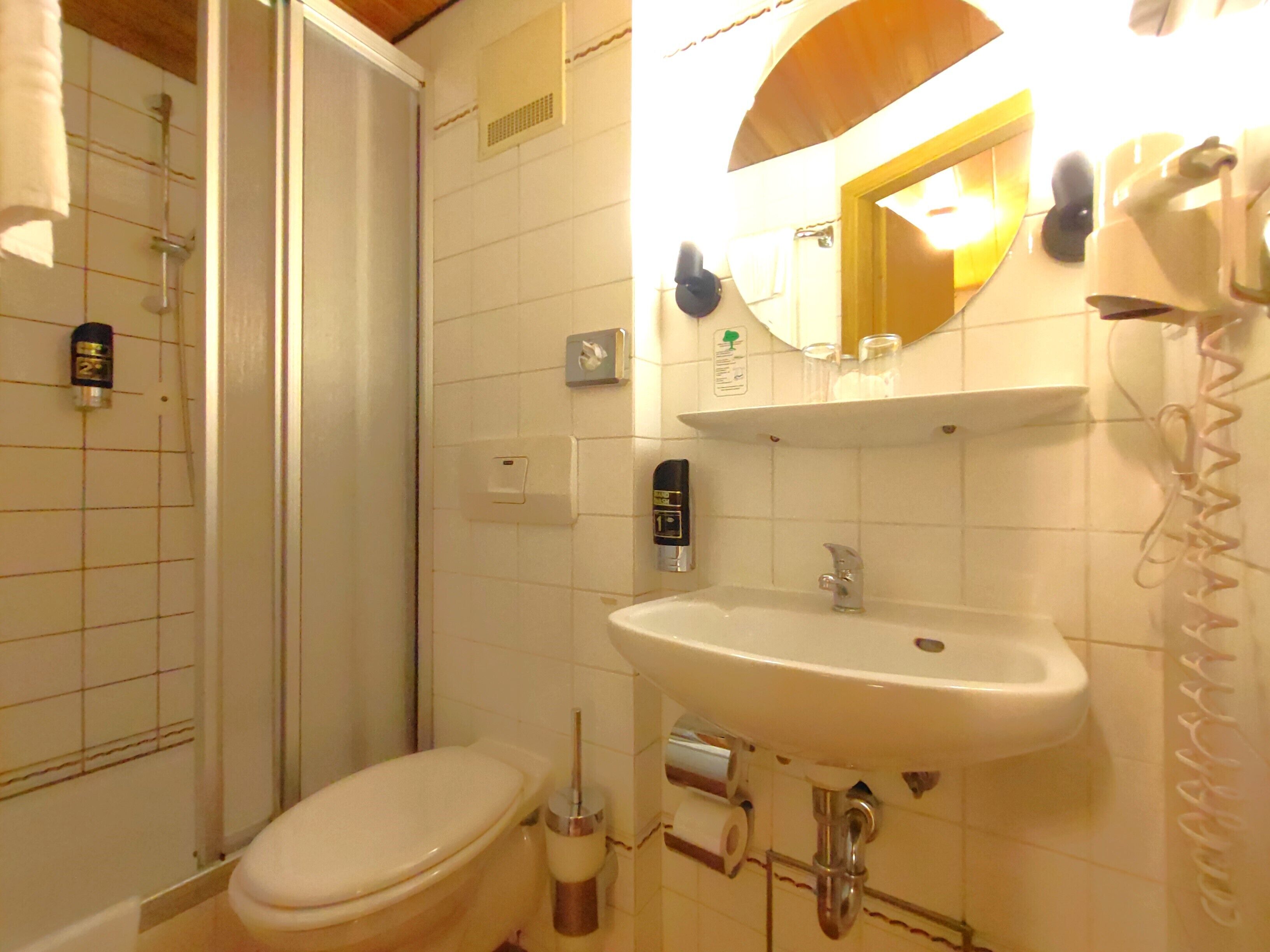A bathroom with a toilet, sink, and shower.