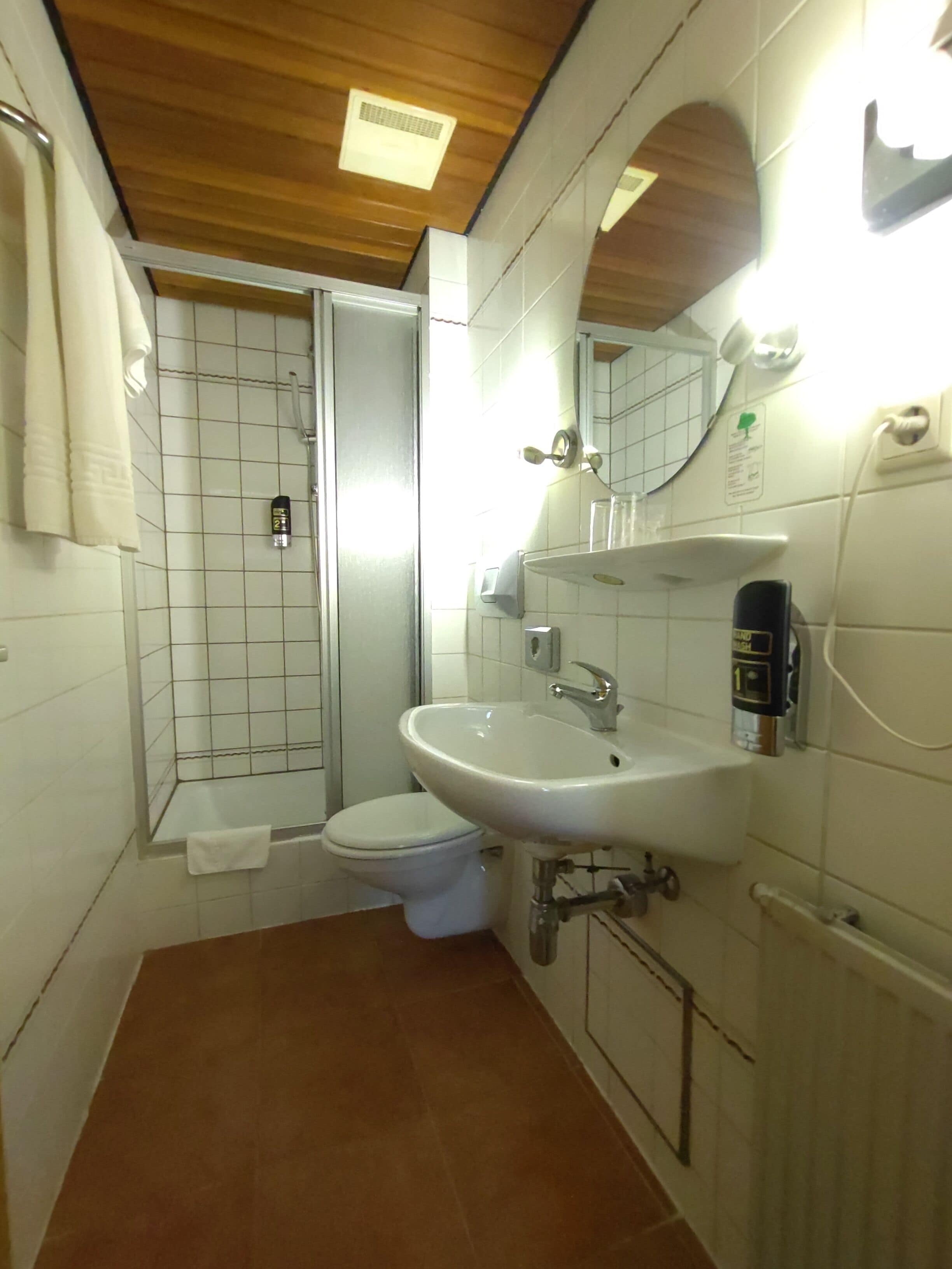 A bathroom with a toilet, sink, and shower.