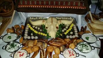 A buffet table with various breads, rolls, and dips.