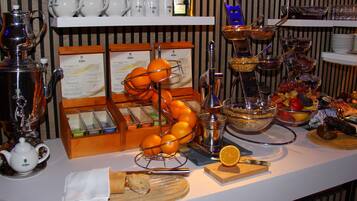 Una barra de buffet con diversos alimentos, una estación de café y una exhibición de teteras.