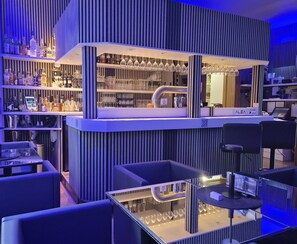 A bar area with shelves of liquor bottles, glasses, and a bar counter. - Hotel Wippertal (Ilberstedt)