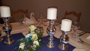 A table set for a formal event with candles, glassware, and a floral centerpiece. - Hotel Wippertal (Ilberstedt)