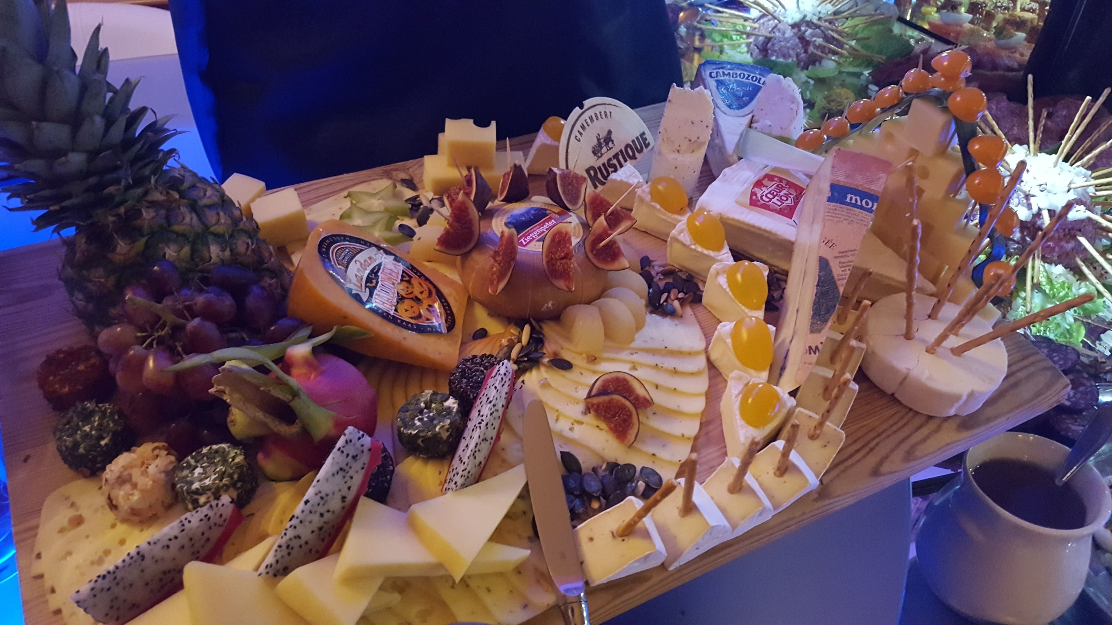 Eine Käseplatte mit verschiedenen Käsesorten, Früchten und Nüssen.