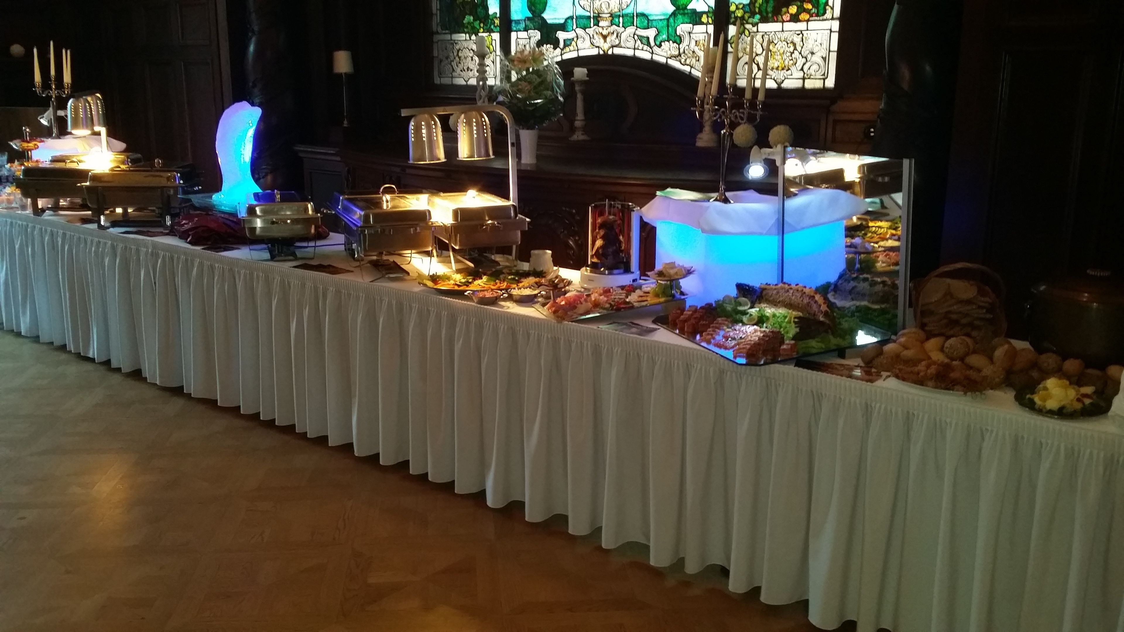 A buffet table with various food items and a decorative backdrop.