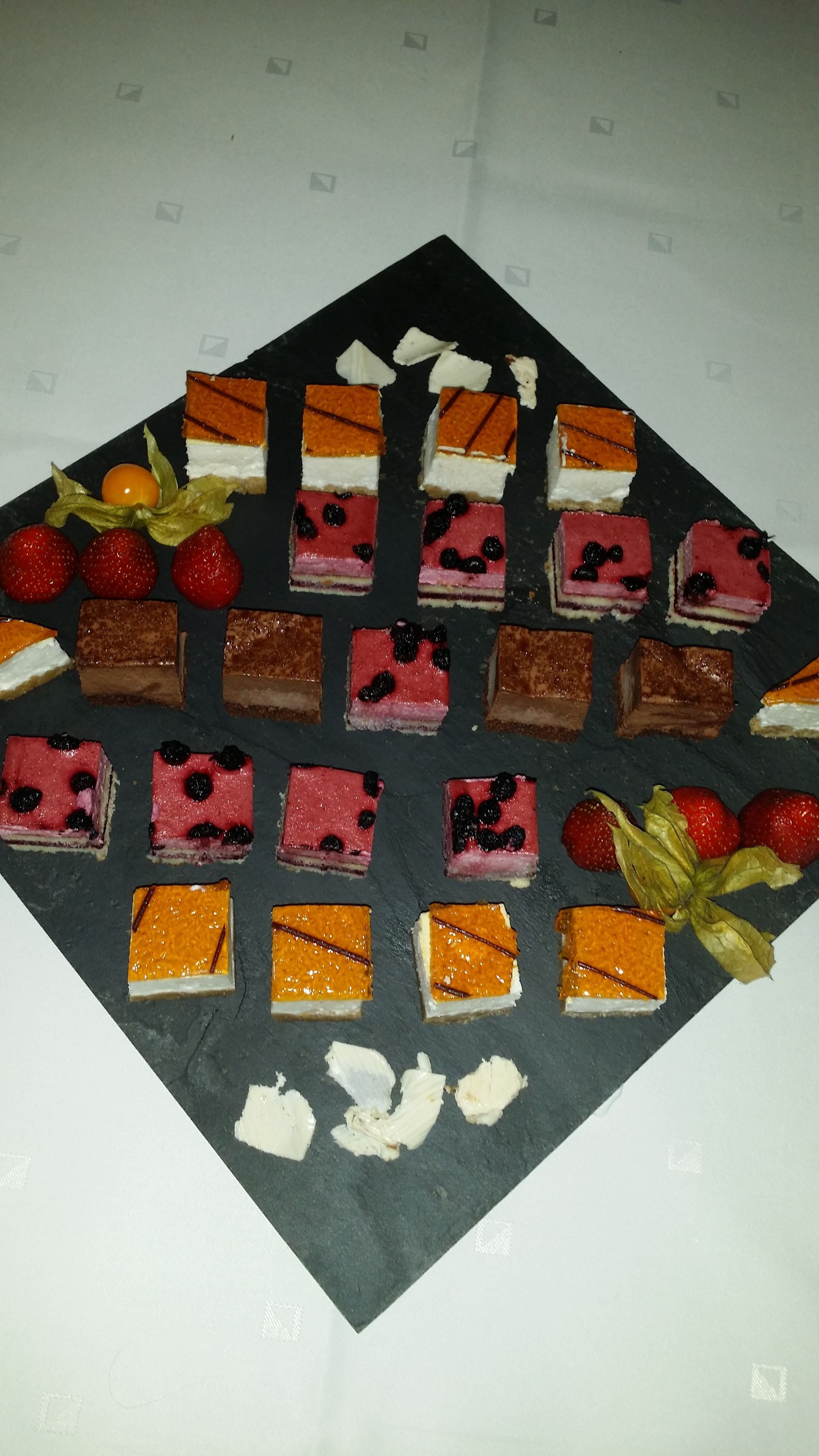 Una variedad de postres dispuestos sobre una bandeja de pizarra.