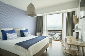 A modern hotel room with a large bed, a desk, and a view of the marina. - Hotel Vincci Puertochico (Santander)