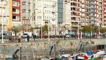 Una marina con numerosos barcos amarrados, rodeada de edificios de varios pisos con balcones y un letrero de hotel.