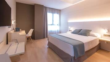 Edredón, minibar y caja de seguridad en la habitación