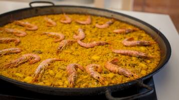 A large pan filled with yellow rice and several shrimp.