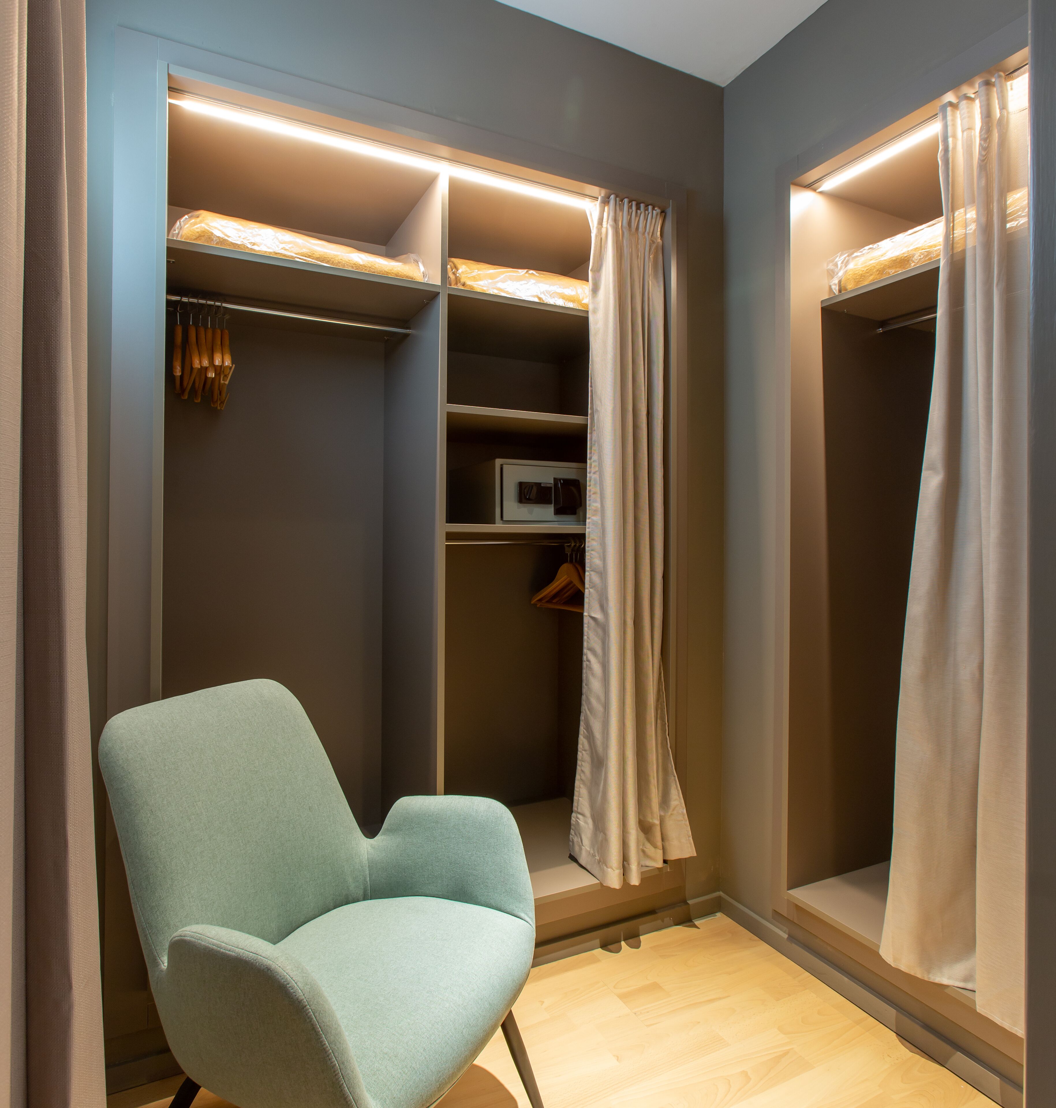 A walk-in closet with a chair, shelves, and hanging space.