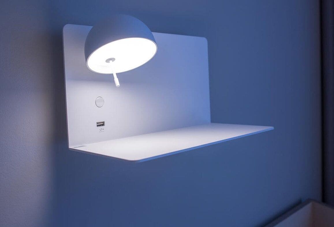 A wall-mounted desk lamp with a white stand and a blue shade.