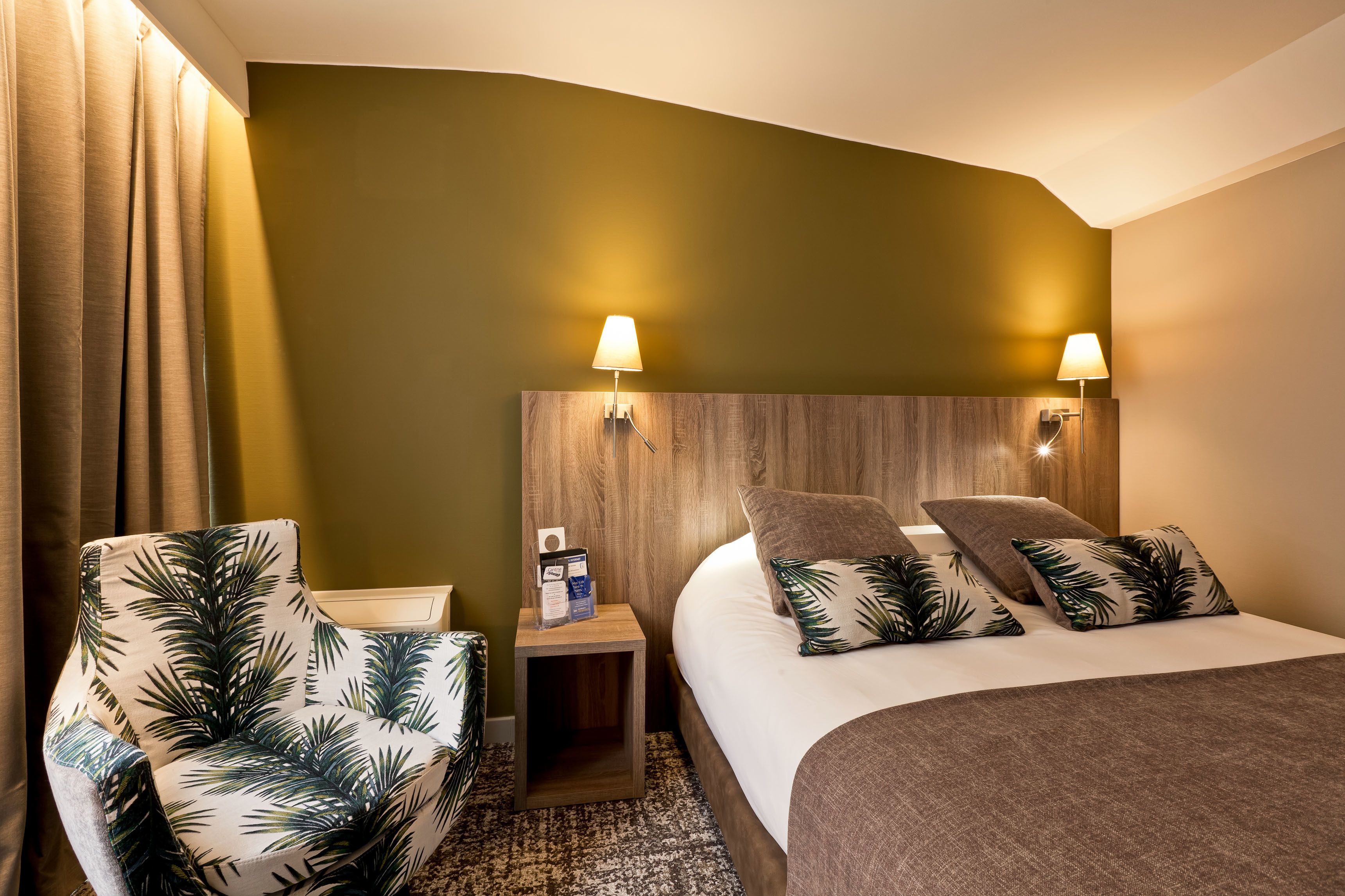 A hotel room with a bed, two nightstands, a chair, and a lamp.