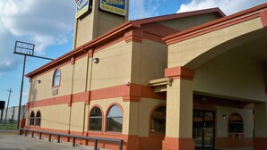 A hotel with a prominent tower sign, a large entrance, and a covered area. - Scottish Inn & Suites (Beaumont)