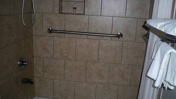 Un bagno dotato di vasca, doccia e portasciugamani.