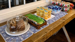 Une table de buffet proposant divers plats et donnant sur une fenêtre.
