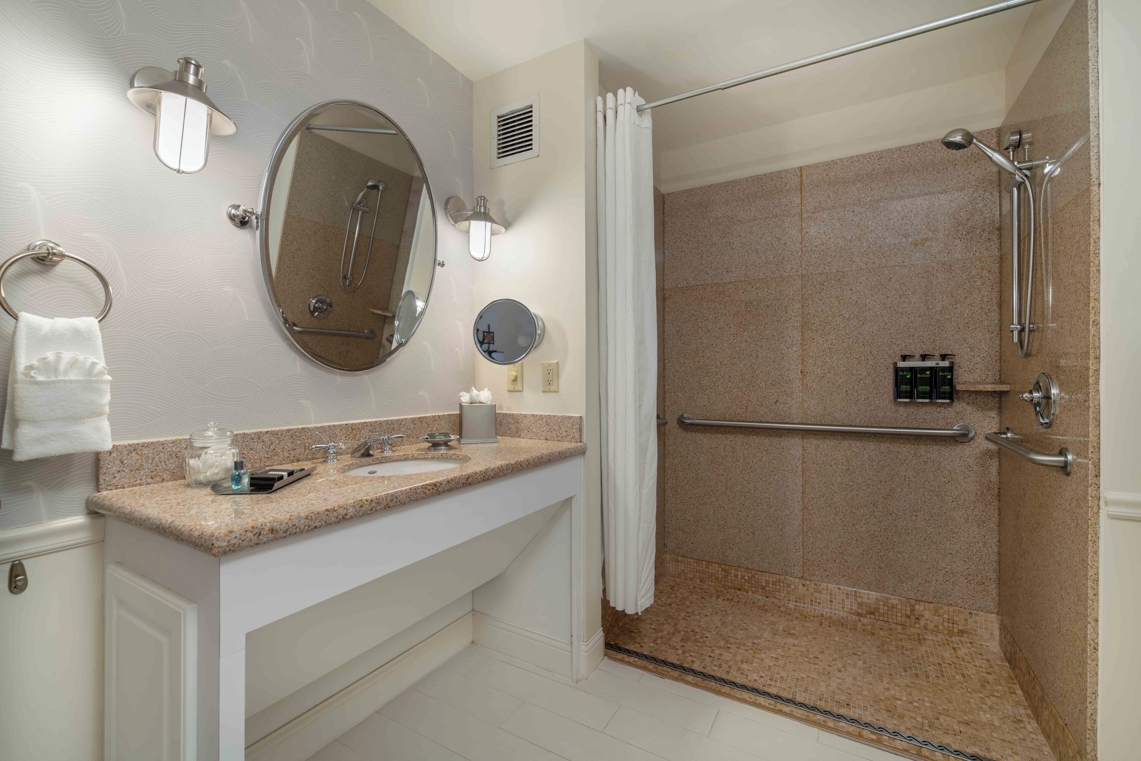 A modern bathroom with a shower, a vanity with a sink, and a mirror.