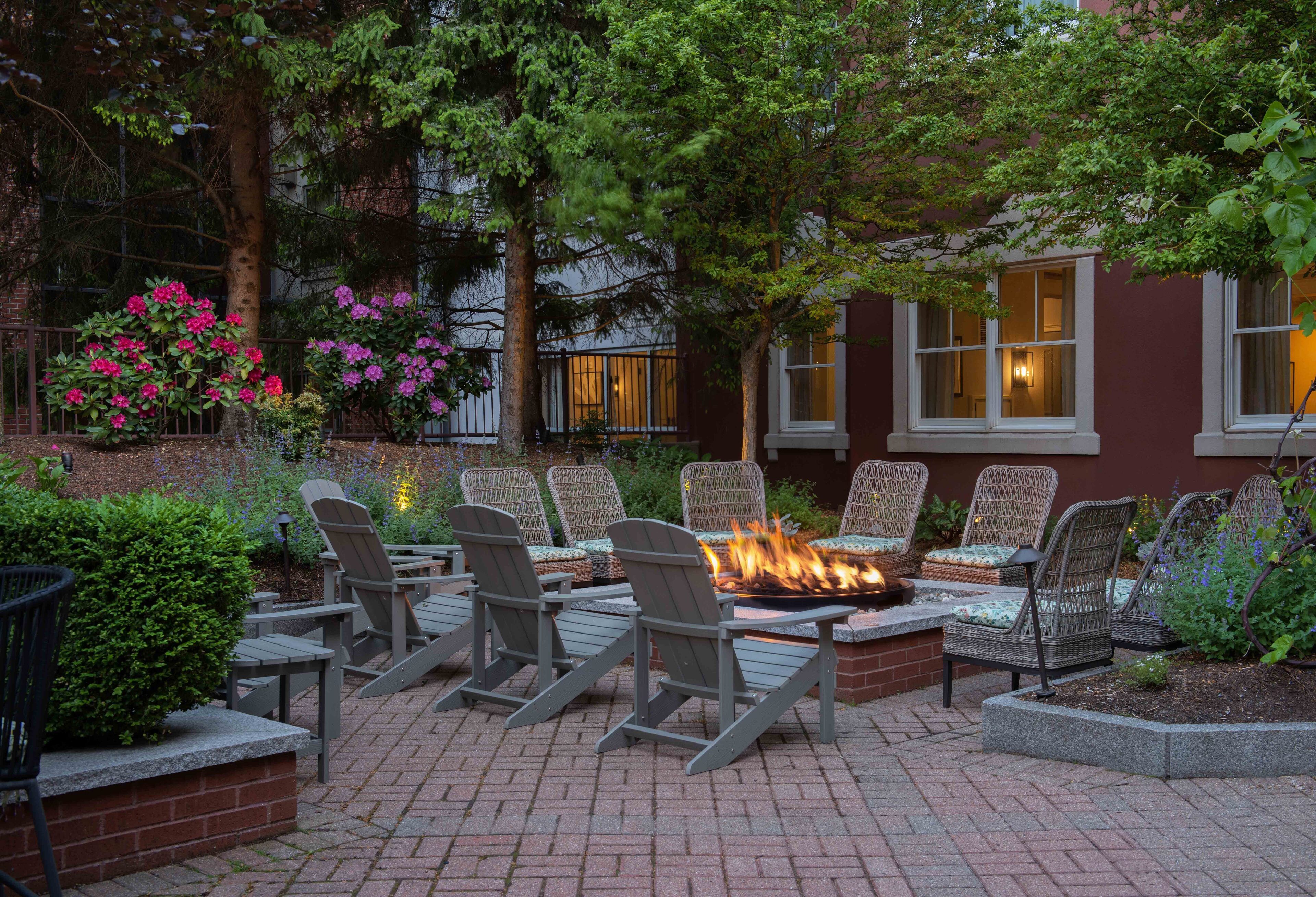 An outdoor seating area with Adirondack chairs and a fire pit.