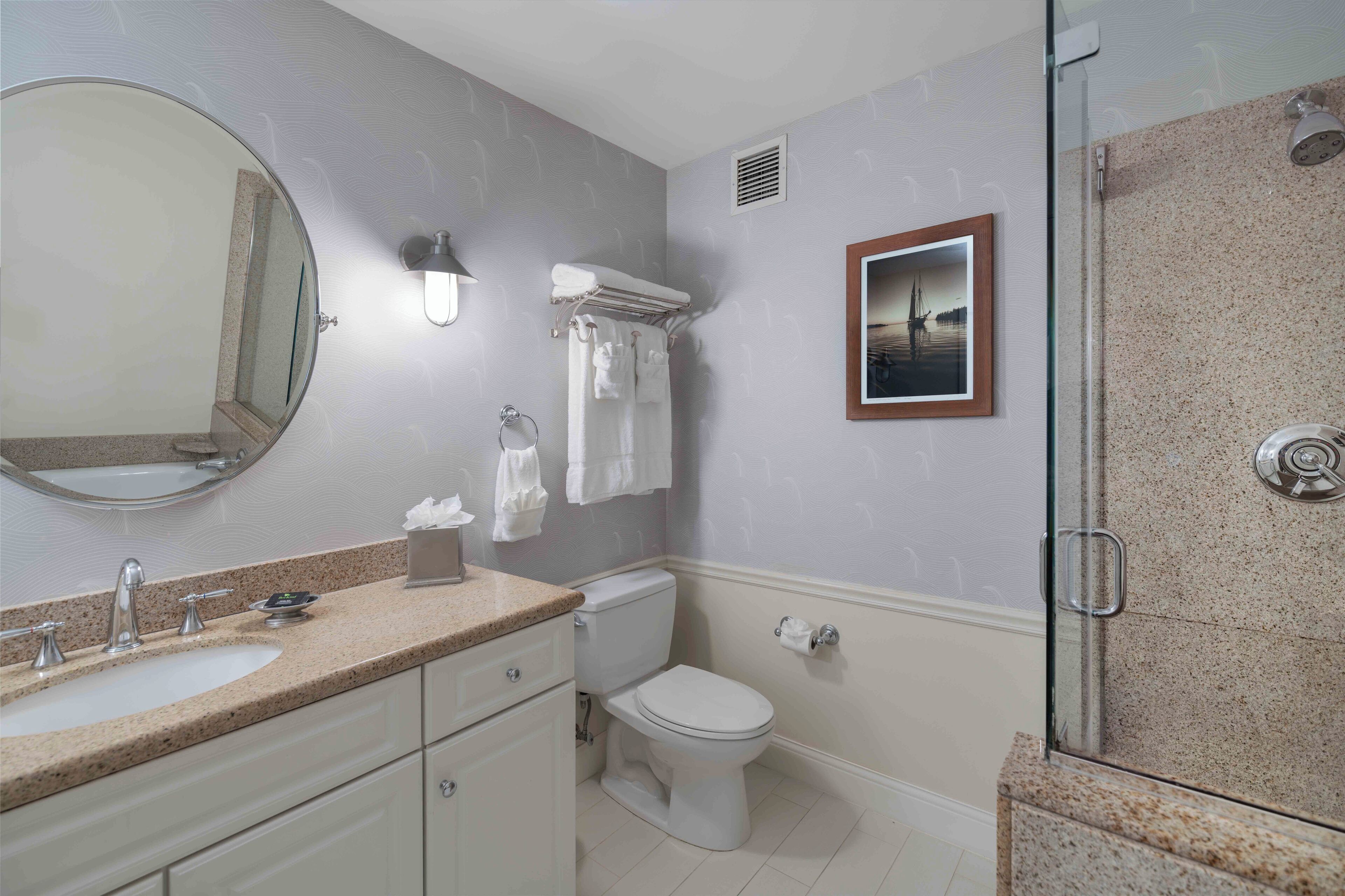 A bathroom with a sink, toilet, and shower.