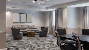 A conference room with a large table, several chairs, a sofa, and a coffee table.