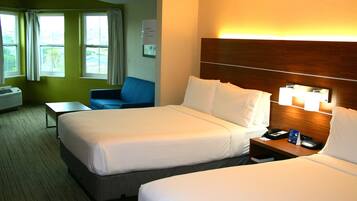 Ein Hotelzimmer mit zwei Betten, einem Schreibtisch, einem Stuhl und einem fenster mit Vorhängen.