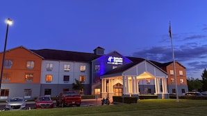 Un hotel Holiday Inn Express con un letrero llamativo, varios espacios de estacionamiento y un césped bien cuidado.
