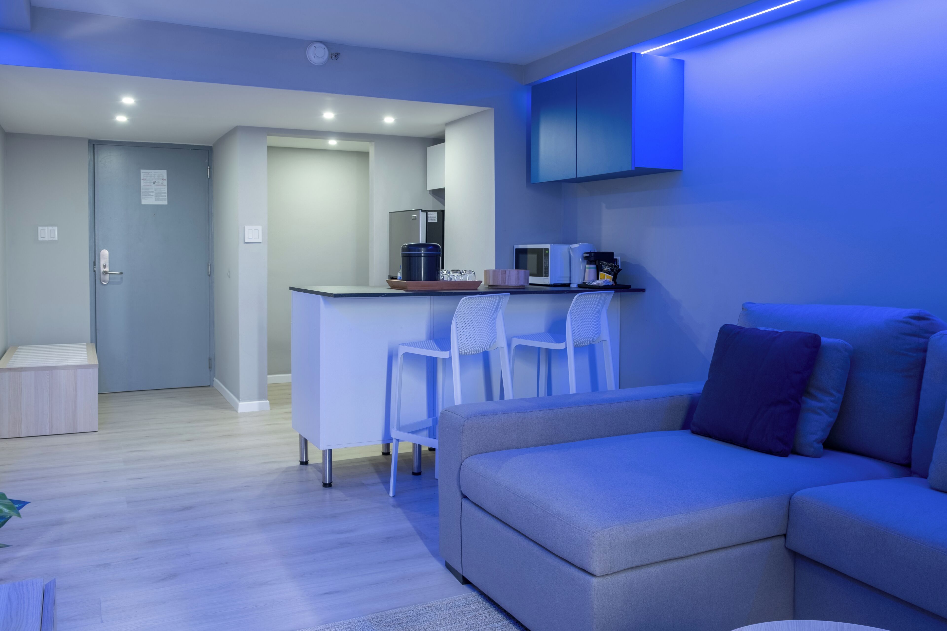 A modern living room with a grey sofa, a small coffee table, and a blue accent wall.