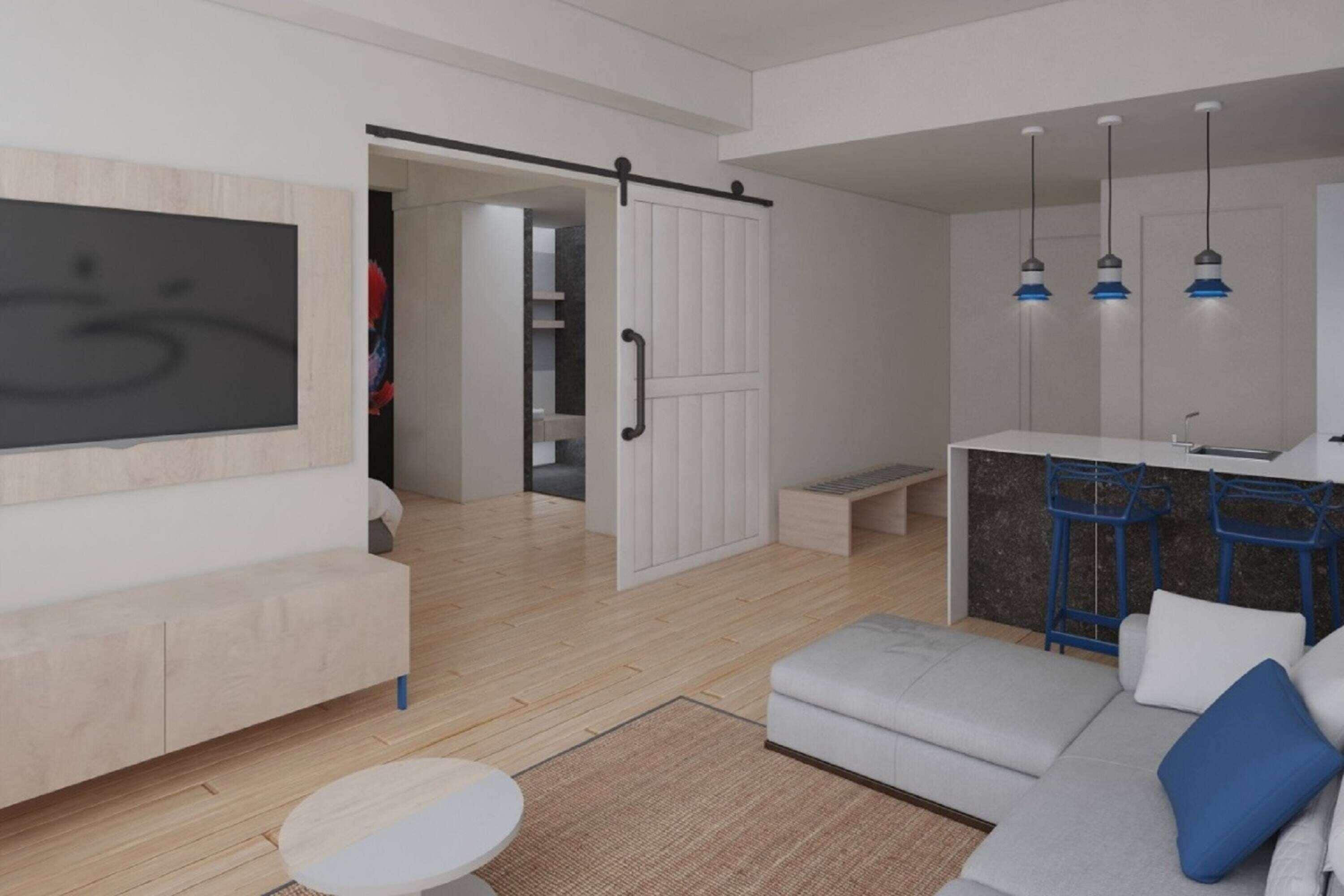 Una sala de estar moderna con un sofá, un reposapiés y un televisor montado en la pared.