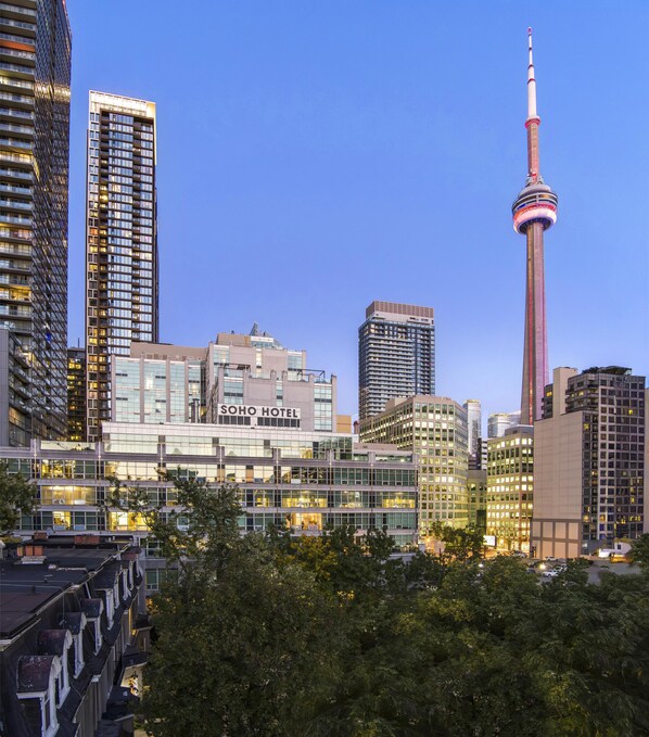 Un hotel con fachada de vidrio moderna, una torre destacada y vistas despejadas del paisaje urbano circundante.