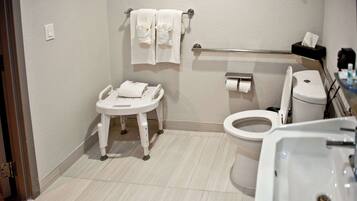 A small, clean bathroom with a toilet, sink, and a baby changing station.