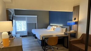 A hotel room with a bed, desk, chair, and a couch. - Comfort Suites Clearwater - Dunedin (Clearwater)