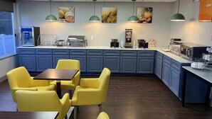 A modern kitchen area with a counter, coffee machines, and seating. - Comfort Suites Clearwater - Dunedin (Clearwater)