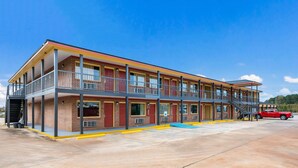 A motel with a two-story structure, multiple balconies, and a red truck parked in front. - Econo Lodge Russellville (Russellville)
