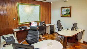Una sala conferenze con pannelli in legno, una grande mappa appesa al muro, un quadro e un cartello con la scritta 'Best Western Plus'.