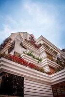 Ein Hotel mit modernem architektonischen Design, mit Balkonen, die mit Pflanzen und Blumen belegt sind.