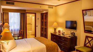 A hotel room with two beds, a TV, a dresser, and a chair.