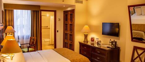 Habitación de hotel con dos camas, televisor, cómoda y una silla.