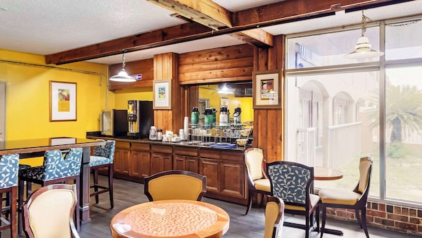 Ein gemütliches Restaurant mit Holzbalken, gelben Wänden und einer Theke mit Kaffeemaschinen.