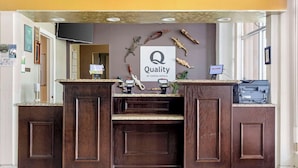 Ein Empfangstresen mit einem Schild, auf dem ‘Quality by Choice Hotels’ steht, umgeben von verschiedenen Reptiliendekorationen.
