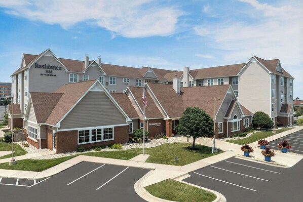 A multi-story hotel with a prominent 'Residence Inn' sign, a parking lot, and a well-maintained lawn.
