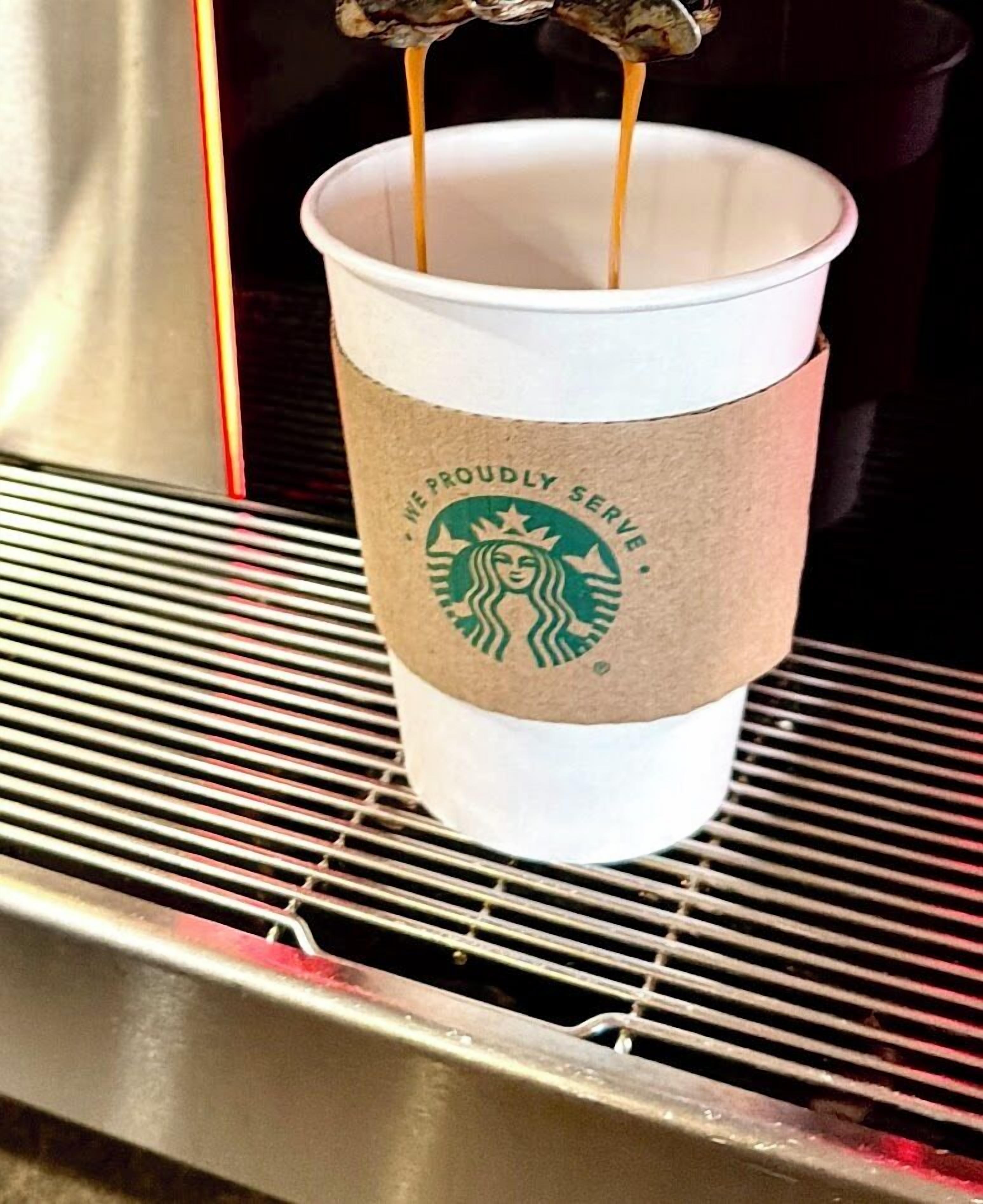 Una taza de Starbucks sobre una parrilla metálica.