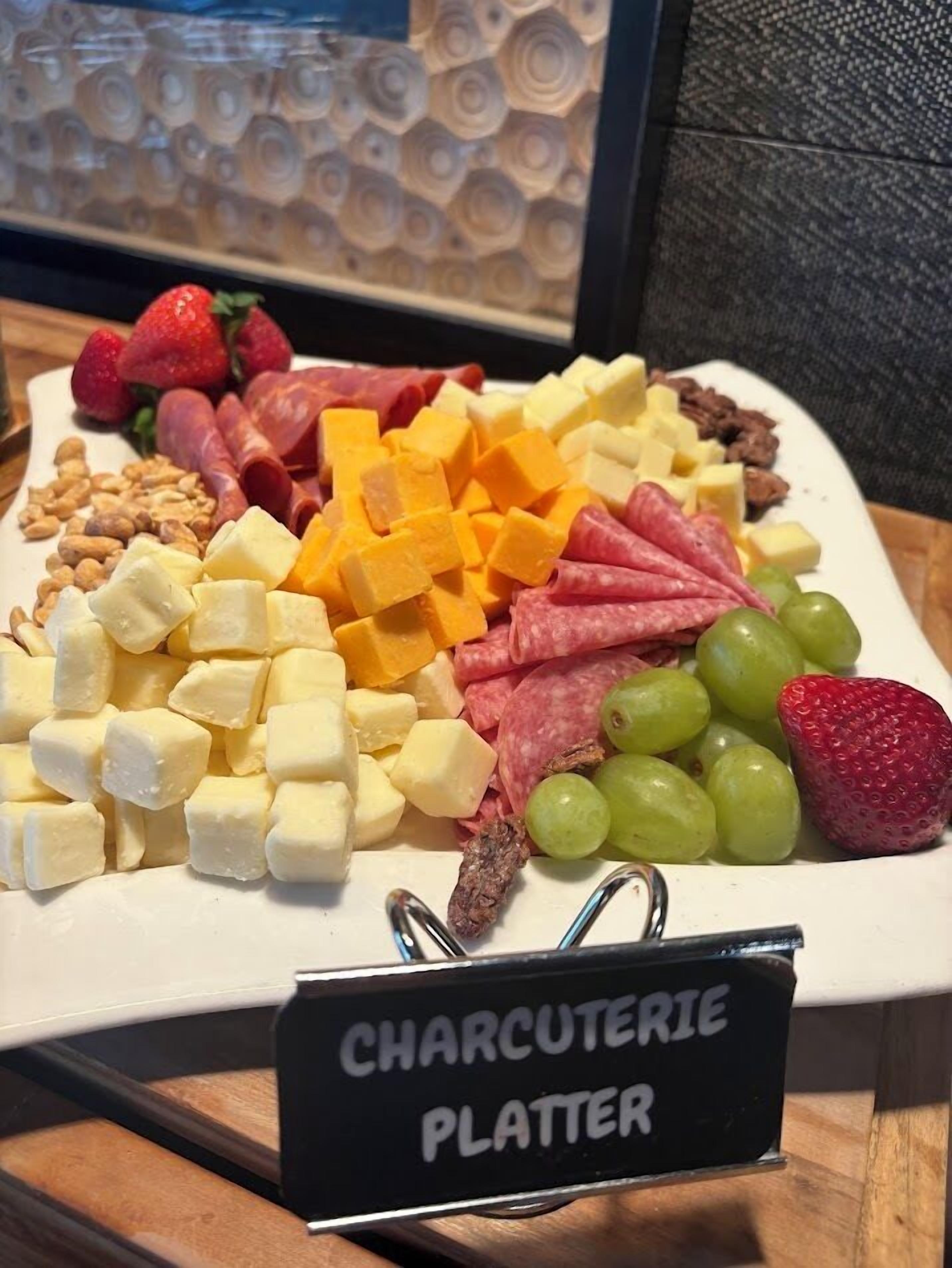 A charcuterie platter with various cheeses, meats, and fruits.