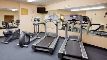 A gym with treadmills, elliptical machines, and a stationary bike.