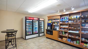 Una tienda de conveniencia con zona de estar, dispensadores de bebidas frías y una amplia variedad de productos envasados.
