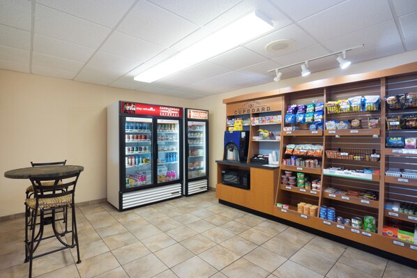 Una tienda de conveniencia con zona de estar, dispensadores de bebidas frías y una amplia variedad de productos envasados.