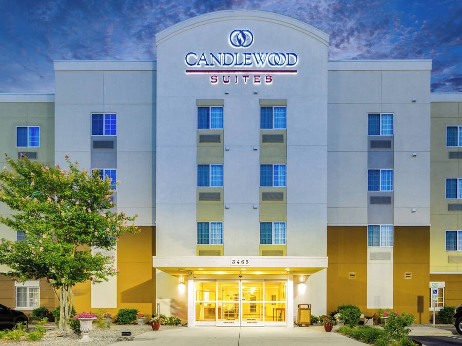 A hotel with a modern facade, a clear sky, and a well-maintained entrance area.