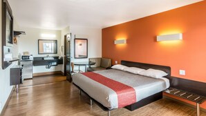 A modern hotel room with a bed, a desk, a chair, and a bathroom. - Motel 6 Bell Gardens, CA - Los Angeles (Bell Gardens)