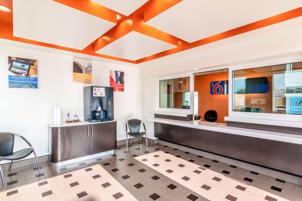 Un área de recepción de diseño moderno, con un mostrador, una silla y una puerta de vidrio con el símbolo de número.