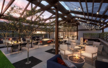 An outdoor patio with wooden pergolas, string lights, and seating areas.