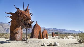 A desert landscape with large, rust-colored rock formations resembling a dragon.